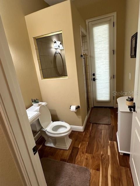 bathroom with hardwood / wood-style flooring and toilet