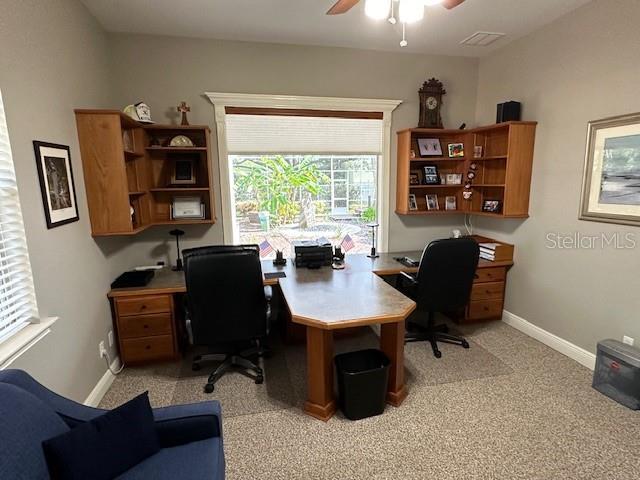 carpeted home office featuring ceiling fan