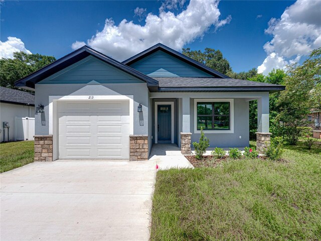 view of front of home featuring a front yard and a garage