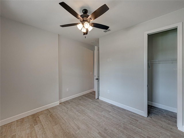 unfurnished bedroom featuring ceiling fan, light wood-type flooring, and a closet