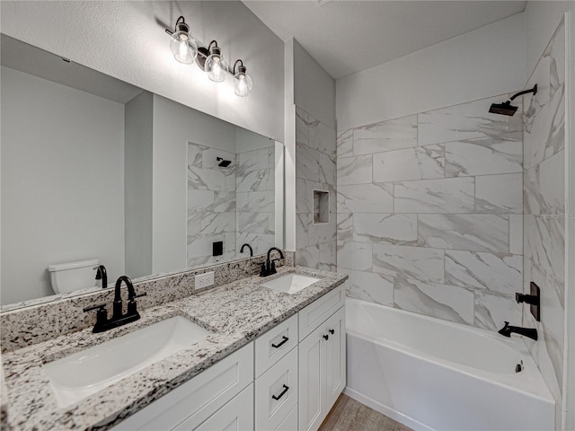 full bathroom with toilet, vanity, and tiled shower / bath