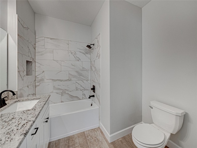 full bathroom featuring vanity, toilet, hardwood / wood-style flooring, and tiled shower / bath