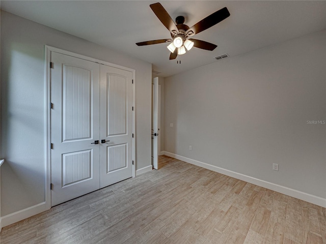 unfurnished bedroom featuring light hardwood / wood-style flooring, a closet, and ceiling fan