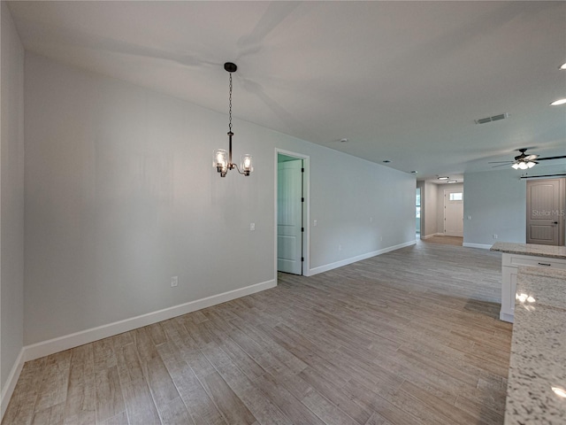 unfurnished room with light hardwood / wood-style floors and ceiling fan with notable chandelier