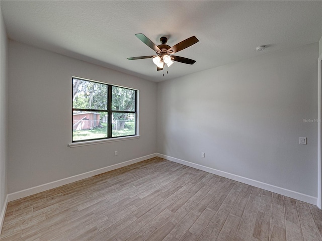 spare room with light hardwood / wood-style flooring, ceiling fan, and a textured ceiling