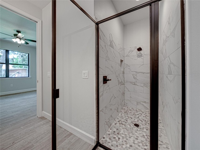 bathroom with hardwood / wood-style flooring, an enclosed shower, and ceiling fan