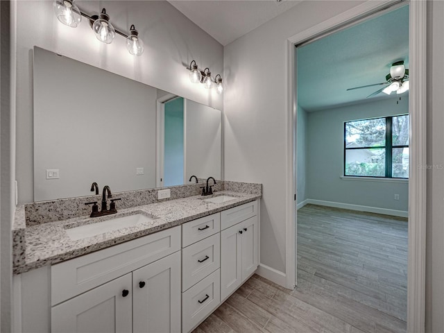 bathroom featuring ceiling fan, dual bowl vanity, and hardwood / wood-style flooring