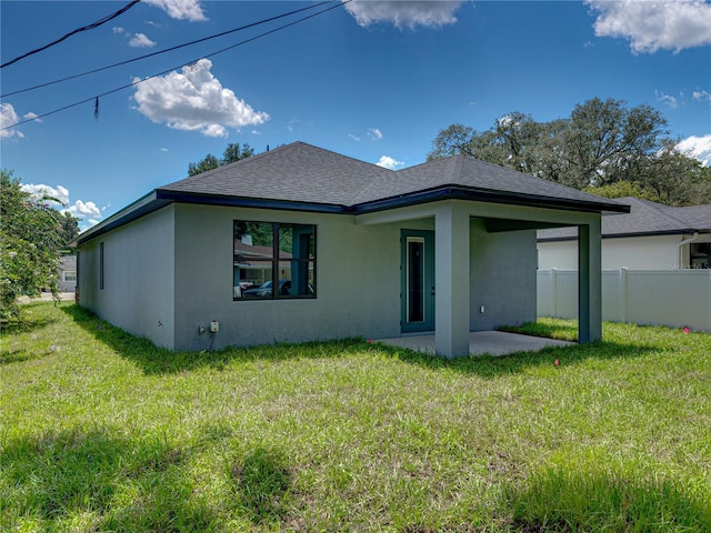 back of property with a yard and a patio