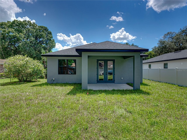 rear view of house featuring a lawn and a patio