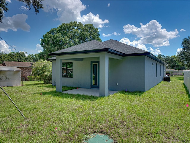 rear view of house with a lawn and a patio