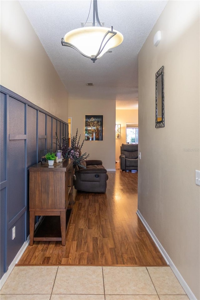 hall featuring a textured ceiling and hardwood / wood-style floors