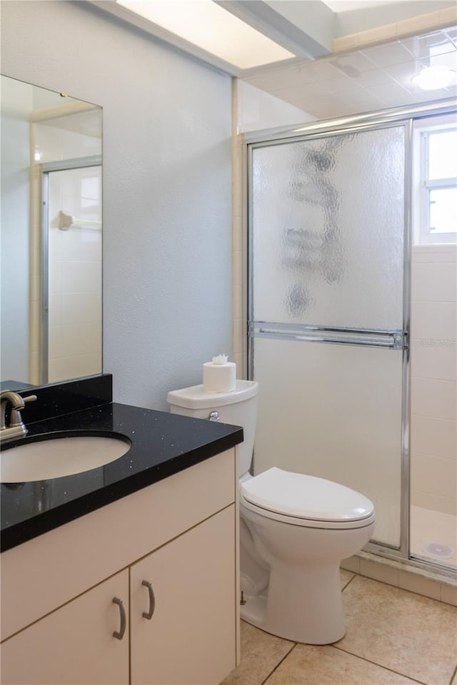 bathroom with vanity, tile patterned floors, walk in shower, and toilet