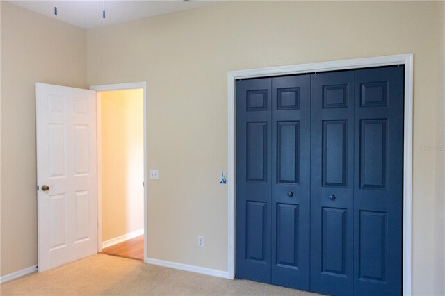 unfurnished bedroom featuring light carpet and a closet