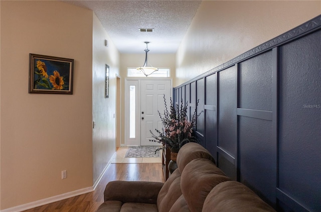 foyer entrance featuring light wood-type flooring and a textured ceiling