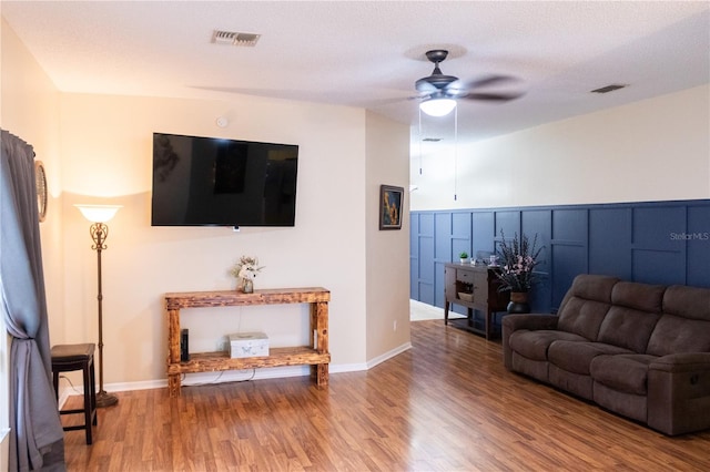 living room featuring a textured ceiling, ceiling fan, and wood-type flooring