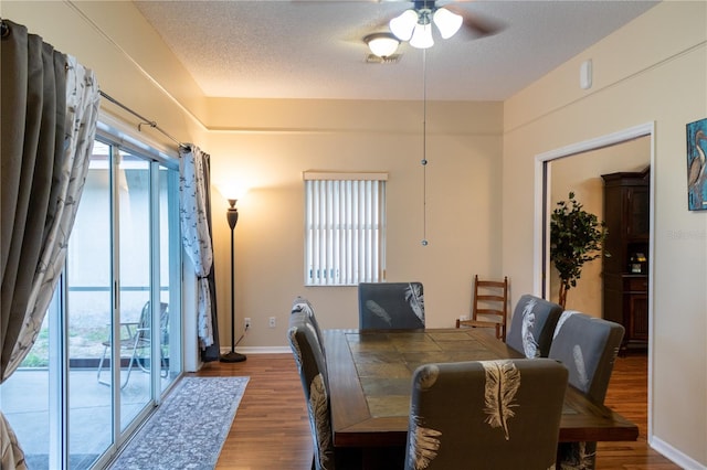 dining space featuring a textured ceiling, ceiling fan, and wood-type flooring