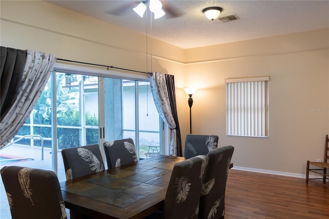 dining area with ceiling fan, a textured ceiling, hardwood / wood-style flooring, and a wealth of natural light