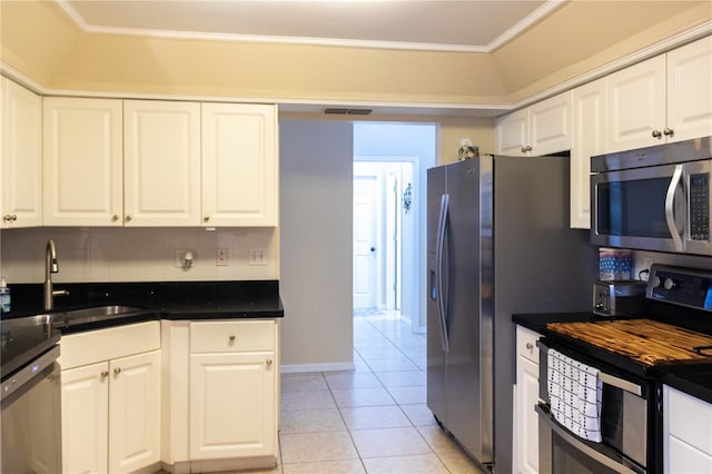 kitchen with appliances with stainless steel finishes, white cabinets, sink, backsplash, and ornamental molding