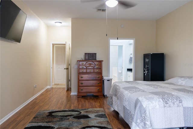 bedroom featuring ensuite bath, dark wood-type flooring, and ceiling fan