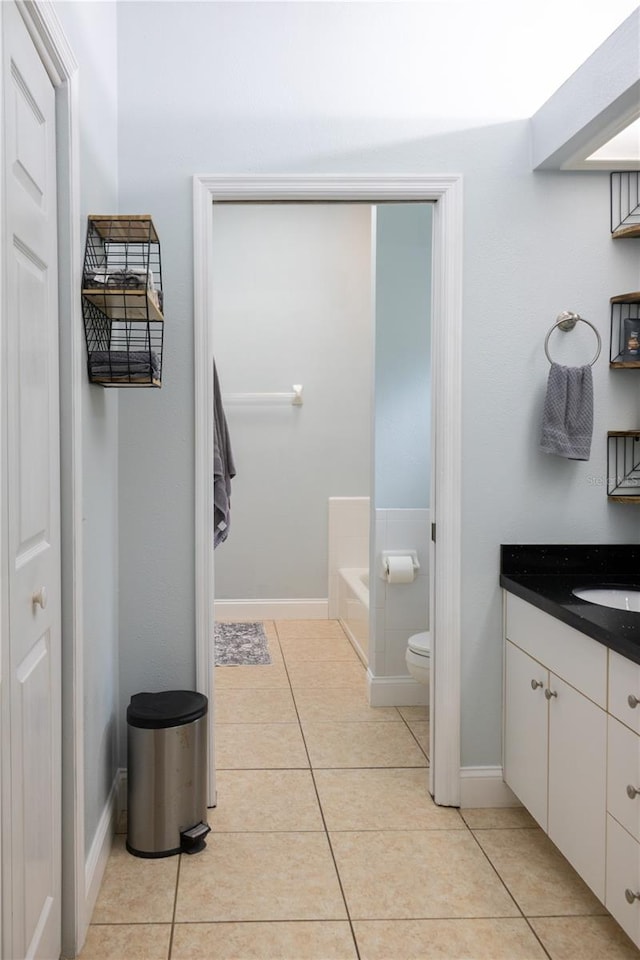 bathroom featuring vanity, tile patterned flooring, a bathtub, and toilet