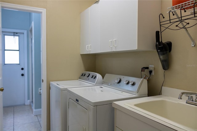 laundry room with light tile patterned floors, independent washer and dryer, sink, and cabinets