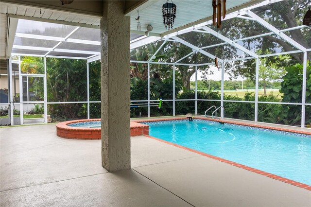 view of pool featuring an in ground hot tub, a lanai, and a patio