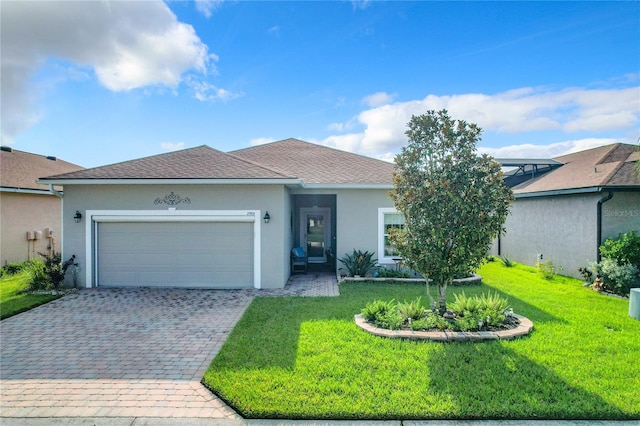 single story home featuring decorative driveway, stucco siding, a shingled roof, an attached garage, and a front lawn