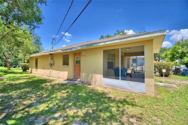 317 C St, Lake Wales, FL 33853 - rear view of house featuring a sunroom, a yard, and stucco siding