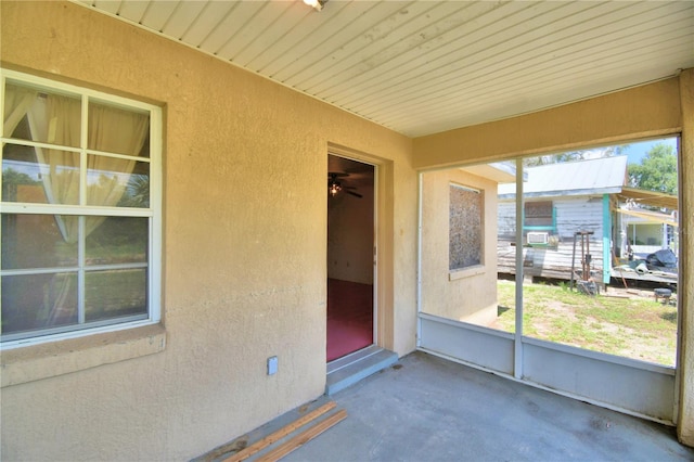 unfurnished sunroom with ceiling fan