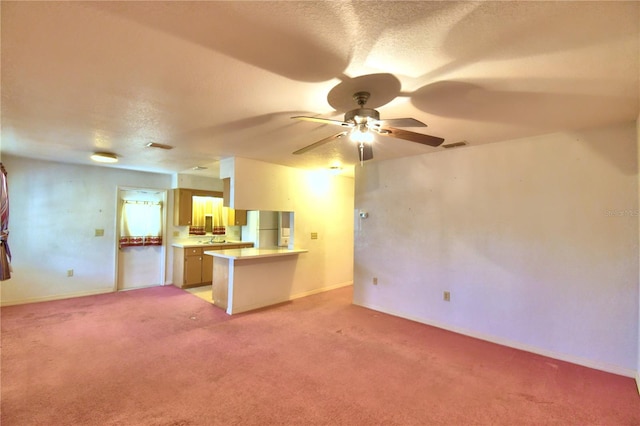 unfurnished living room featuring ceiling fan and carpet flooring