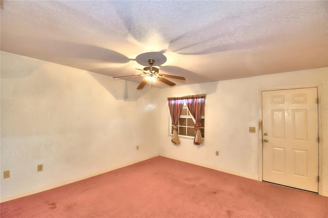 empty room featuring a textured ceiling, ceiling fan, and carpet floors