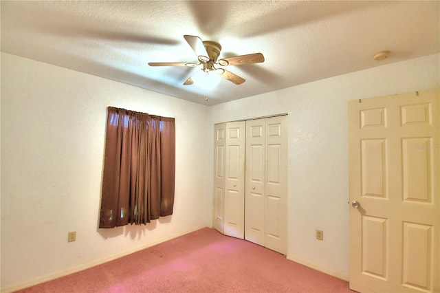 unfurnished bedroom featuring ceiling fan, a textured ceiling, carpet floors, and a closet