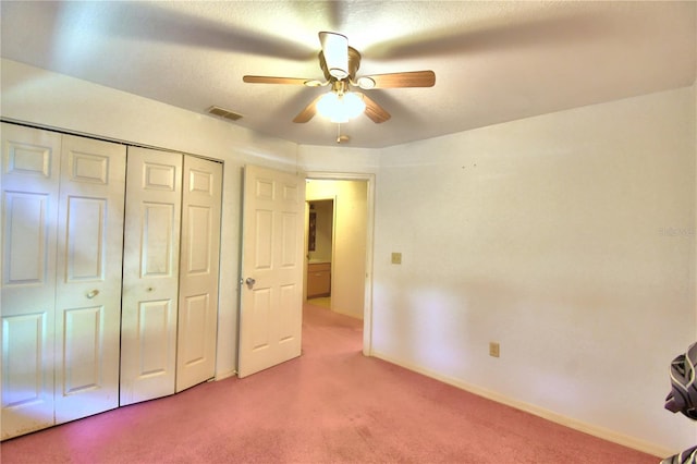 unfurnished bedroom with ceiling fan, carpet floors, and a closet