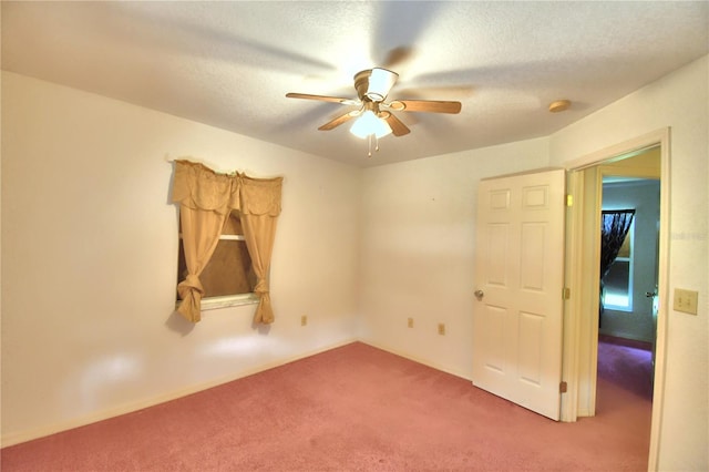 carpeted empty room with ceiling fan and a textured ceiling