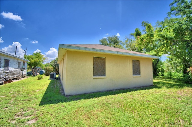 view of property exterior with central AC and a lawn