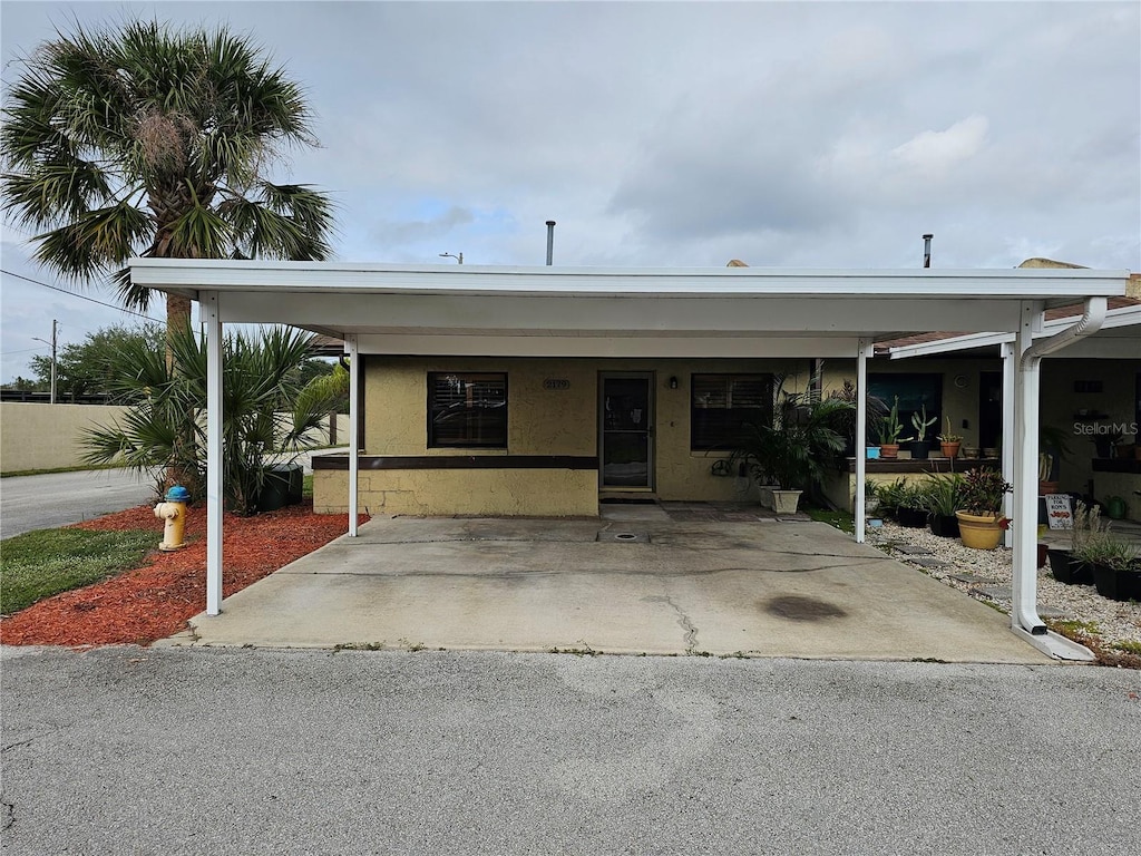 view of front facade with an attached carport and stucco siding