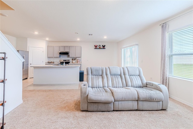 living room featuring light carpet and plenty of natural light