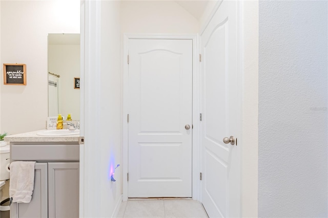 hall featuring light tile patterned floors and sink