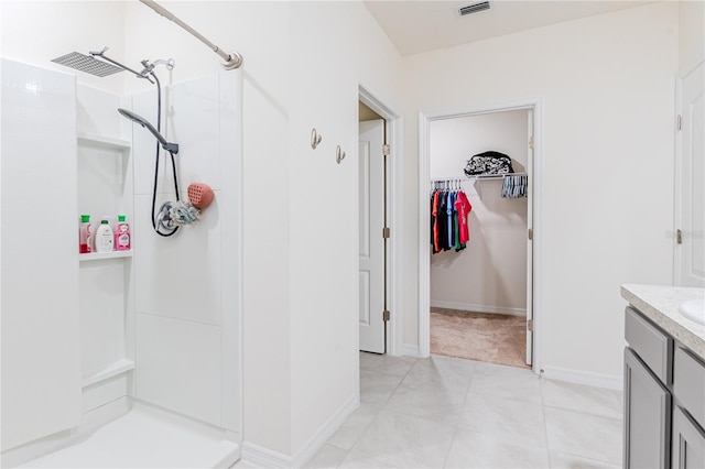 bathroom featuring tile patterned floors, vanity, and a shower