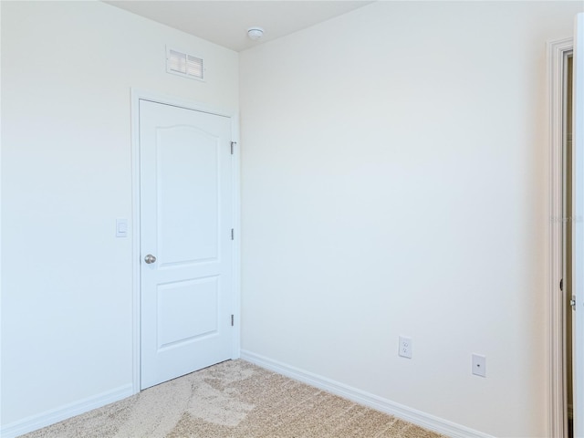 spare room featuring light colored carpet