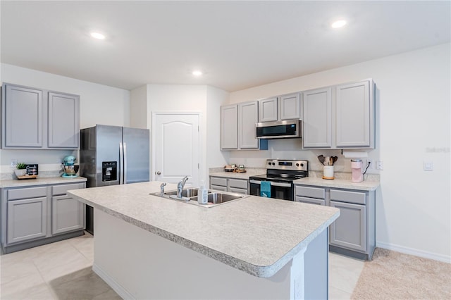 kitchen featuring stainless steel appliances, a kitchen island with sink, gray cabinets, sink, and light tile patterned flooring