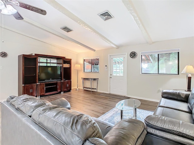 living room with visible vents, lofted ceiling with beams, baseboards, and wood finished floors