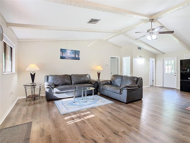 living room with visible vents, lofted ceiling with beams, baseboards, and wood finished floors