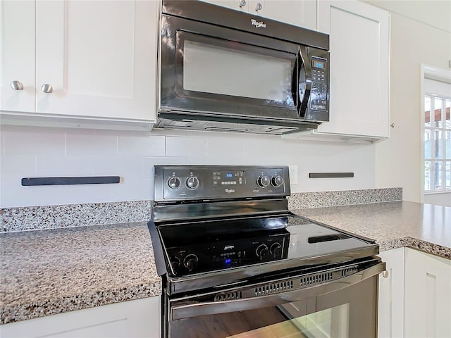 kitchen with tasteful backsplash, light countertops, white cabinetry, and black appliances