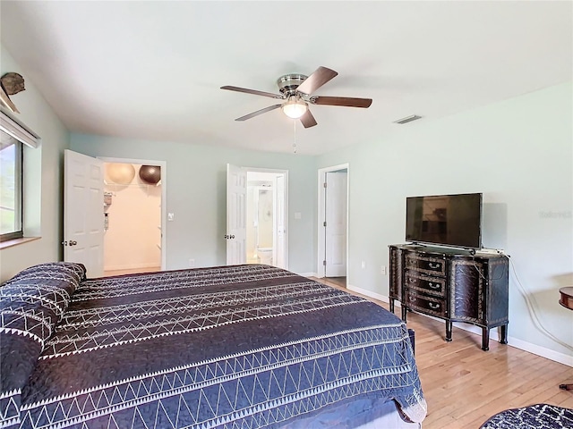 bedroom with ceiling fan, wood finished floors, visible vents, and baseboards