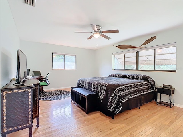 bedroom with hardwood / wood-style floors, a ceiling fan, visible vents, and baseboards