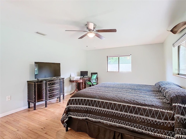 bedroom with a ceiling fan, baseboards, visible vents, and wood finished floors