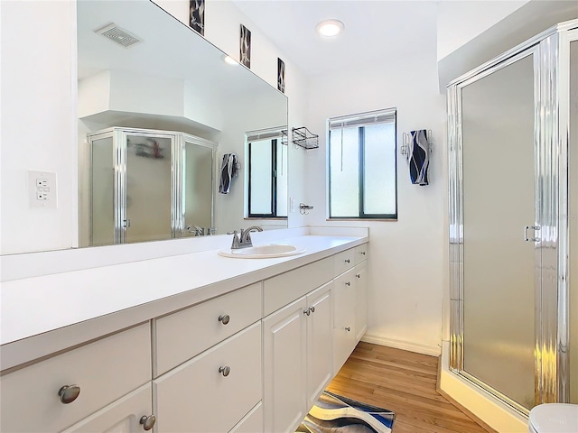 bathroom with visible vents, a shower stall, vanity, and wood finished floors