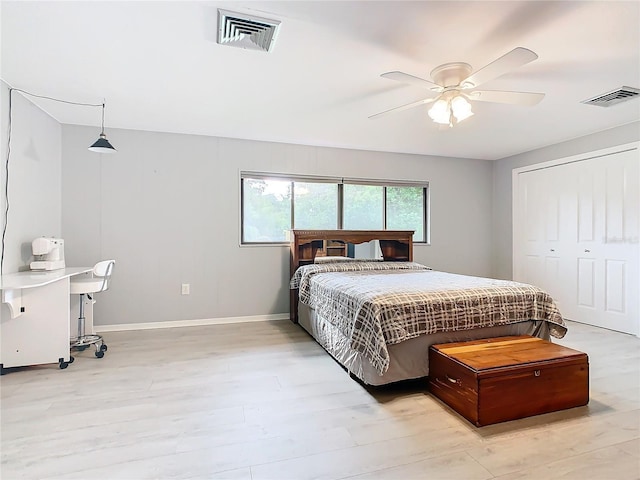 bedroom featuring light wood finished floors, baseboards, visible vents, and ceiling fan