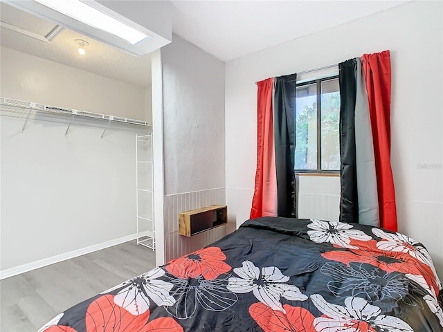 bedroom featuring baseboards and wood finished floors